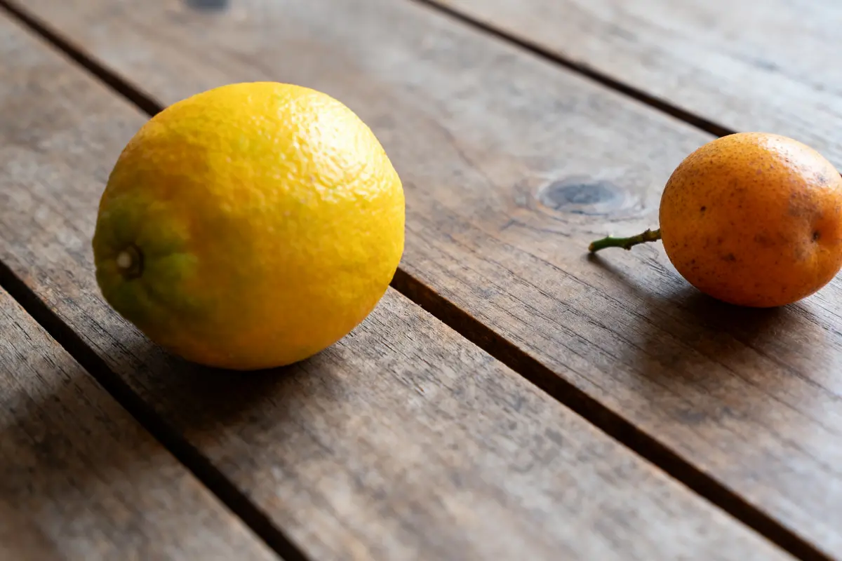 Deux fruits jaunes sur une table en bois, mettant en valeur le fruit en y.